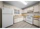 This kitchen features white appliances and cabinets, complemented by stylish gray flooring for a clean and modern look at 1115 Silver Rd, Ocala, FL 34472