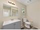 Cozy bathroom featuring a grey vanity, a standard toilet, and a framed mirror at 11153 Sw 79Th Ave, Ocala, FL 34476