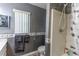 Updated bathroom featuring grey walls, laminate floors, a shower, and a toilet at 1213 Meadowbend Dr, Leesburg, FL 34748