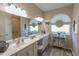 Bright bathroom with a dual sink vanity, framed mirrors, and stylish decorative touches at 1213 Meadowbend Dr, Leesburg, FL 34748