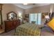 Bedroom featuring decorative bedding, laminate flooring, and a dresser with a large mirror at 1213 Meadowbend Dr, Leesburg, FL 34748