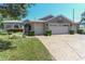 Beautiful single-story home with three-car garage, lovely landscaping, and stamped driveway at 1213 Meadowbend Dr, Leesburg, FL 34748
