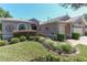 Charming single-story home features a three-car garage and lush, landscaped front yard at 1213 Meadowbend Dr, Leesburg, FL 34748