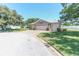 Well maintained house exterior with a three car garage, paver driveway and manicured lawn at 1213 Meadowbend Dr, Leesburg, FL 34748