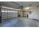 Bright garage interior features a concrete floor, white cabinets, and an automatic garage door opener at 1213 Meadowbend Dr, Leesburg, FL 34748