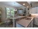 Kitchen and dining area featuring laminate floors, breakfast bar, and open access to a window-filled dining nook at 1213 Meadowbend Dr, Leesburg, FL 34748