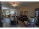 Warm living space includes wood floors, a ceiling fan, and comfortable seating arrangements at 1213 Meadowbend Dr, Leesburg, FL 34748