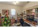 Cozy office with built-in shelving, a wood desk, a ceiling fan, and natural light from the window at 1213 Meadowbend Dr, Leesburg, FL 34748