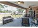 Screened lanai featuring outdoor seating, ceiling fans, grilling area, and views of the lush backyard at 1213 Meadowbend Dr, Leesburg, FL 34748