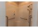 Close-up of a shower featuring grab bars and a hand-held shower head with white tiling at 1213 Meadowbend Dr, Leesburg, FL 34748