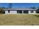 View of backyard with spacious lawn, gray exterior, and covered patio at 13154 Sw 69Th Ct, Ocala, FL 34473