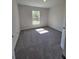 Bright bedroom with soft carpeting, a neutral color scheme, and a sunlit window enhancing the ambiance at 13154 Sw 69Th Ct, Ocala, FL 34473