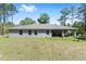 Exterior shot of a single-Gathering home featuring a spacious backyard and covered patio area at 13164 Sw 78Th Place, Dunnellon, FL 34432