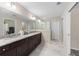 A sleek bathroom featuring a double vanity, marble counters, and a frameless glass walk-in shower at 13164 Sw 78Th Place, Dunnellon, FL 34432