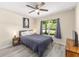 Stylish bedroom featuring wood-look floors, a gray bedspread, and a scenic view at 13164 Sw 78Th Place, Dunnellon, FL 34432