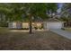 Charming single-story home with stone accents, a two-car garage, and a well-manicured front lawn at dusk at 13164 Sw 78Th Place, Dunnellon, FL 34432