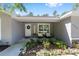 Inviting front porch with a 'Welcome' sign, decorative wreath, seating, and lush landscaping at 13164 Sw 78Th Place, Dunnellon, FL 34432