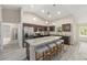 Open kitchen with island seating, stainless appliances, dark cabinets, and seamless flow to other living spaces at 13164 Sw 78Th Place, Dunnellon, FL 34432