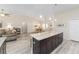 Open concept design featuring a large kitchen island with stone countertop and view into the dining and living spaces at 13164 Sw 78Th Place, Dunnellon, FL 34432