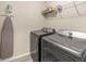 Functional laundry room featuring modern washer, dryer, ironing board and convenient shelf storage at 13164 Sw 78Th Place, Dunnellon, FL 34432