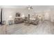 Open-concept living room with gray wood floors, neutral paint, and vaulted ceiling at 13164 Sw 78Th Place, Dunnellon, FL 34432