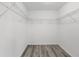 Empty walk-in closet with wire shelving and gray wood-look flooring is ready for your personal design at 13164 Sw 78Th Place, Dunnellon, FL 34432