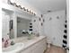 A bathroom with a double sink vanity and a bright, well-lit mirror at 13800 Sw 33Rd Court Rd, Ocala, FL 34473