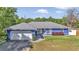 Charming single-story home with a well-maintained lawn, gray roof, and a two-car garage at 13800 Sw 33Rd Court Rd, Ocala, FL 34473