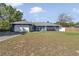 Street view featuring the blue siding, gray roof, landscaping, and two-car garage at 13800 Sw 33Rd Court Rd, Ocala, FL 34473