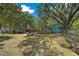Backyard featuring grassy lawn with shade trees, deck, and chain link fence, perfect for outdoor enjoyment at 14190 Ne 209Th Ct, Fort Mc Coy, FL 32134