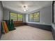 This room has gray walls, two windows, wood-look tile floors, and a black base trim at 14190 Ne 209Th Ct, Fort Mc Coy, FL 32134