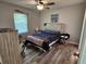 Comfortable bedroom with rustic wood-look flooring, ceiling fan, and natural light at 1441 Admiral Nimitz Ave, Daytona Beach, FL 32124