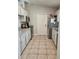 Functional kitchen featuring tile floors, sleek countertops, stainless steel appliances, and painted cabinets at 1441 Admiral Nimitz Ave, Daytona Beach, FL 32124