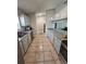 Traditional kitchen featuring tile flooring, white cabinetry, stainless steel appliances, and generous counter space at 1441 Admiral Nimitz Ave, Daytona Beach, FL 32124