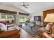 Bright living room featuring a ceiling fan, sliding glass doors and wood-look floors at 15426 Sw 14Th Avenue Rd, Ocala, FL 34473