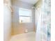 A well-lit bathtub and shower combination with tiled walls and a seashell-themed shower curtain at 17901 Sw 25Th Avenue Rd, Ocala, FL 34473