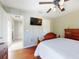 Bright bedroom featuring a wood bed frame, wall-mounted TV, and view into the hallway at 17901 Sw 25Th Avenue Rd, Ocala, FL 34473
