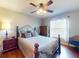 Comfortable bedroom featuring hardwood floors, a ceiling fan, and a large window providing natural light at 17901 Sw 25Th Avenue Rd, Ocala, FL 34473