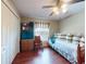 Bright bedroom featuring a daybed with decorative pillows, hardwood floors, and a window at 17901 Sw 25Th Avenue Rd, Ocala, FL 34473