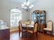 Dining room with a chandelier, arched window, wood floors, and furniture adjacent to a china cabinet at 17901 Sw 25Th Avenue Rd, Ocala, FL 34473