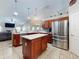 Open kitchen with stainless steel appliances, cherry cabinets, and an island at 17901 Sw 25Th Avenue Rd, Ocala, FL 34473