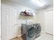 Spacious laundry room featuring a modern washer and dryer set, shelving, and tiled flooring at 17901 Sw 25Th Avenue Rd, Ocala, FL 34473