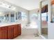 Bright main bathroom features tile floors, double vanity, soaking tub, walk-in shower, and ample natural light at 17901 Sw 25Th Avenue Rd, Ocala, FL 34473
