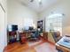 Well-lit office space featuring hardwood floors, an arched window, and a functional workspace with dual monitors at 17901 Sw 25Th Avenue Rd, Ocala, FL 34473