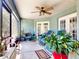Cozy screened patio with comfortable seating, potted plants, and a ceiling fan for relaxing outdoors at 17901 Sw 25Th Avenue Rd, Ocala, FL 34473