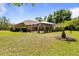Large backyard with a screened pool enclosure, mature landscaping, and ample green space at 21939 Sw 85Th Loop, Dunnellon, FL 34431