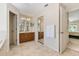 Bright bathroom features double sinks, a linen closet, neutral tile, and access to a bedroom at 21939 Sw 85Th Loop, Dunnellon, FL 34431