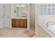 Spacious bathroom with double vanity, tiled shower, and soaking tub with glass block accents at 21939 Sw 85Th Loop, Dunnellon, FL 34431