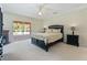 Bedroom boasts a sliding glass door to the lanai, fireplace, and neutral carpeting at 21939 Sw 85Th Loop, Dunnellon, FL 34431