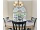 Bright dining area featuring a modern chandelier and a large arched window at 21939 Sw 85Th Loop, Dunnellon, FL 34431